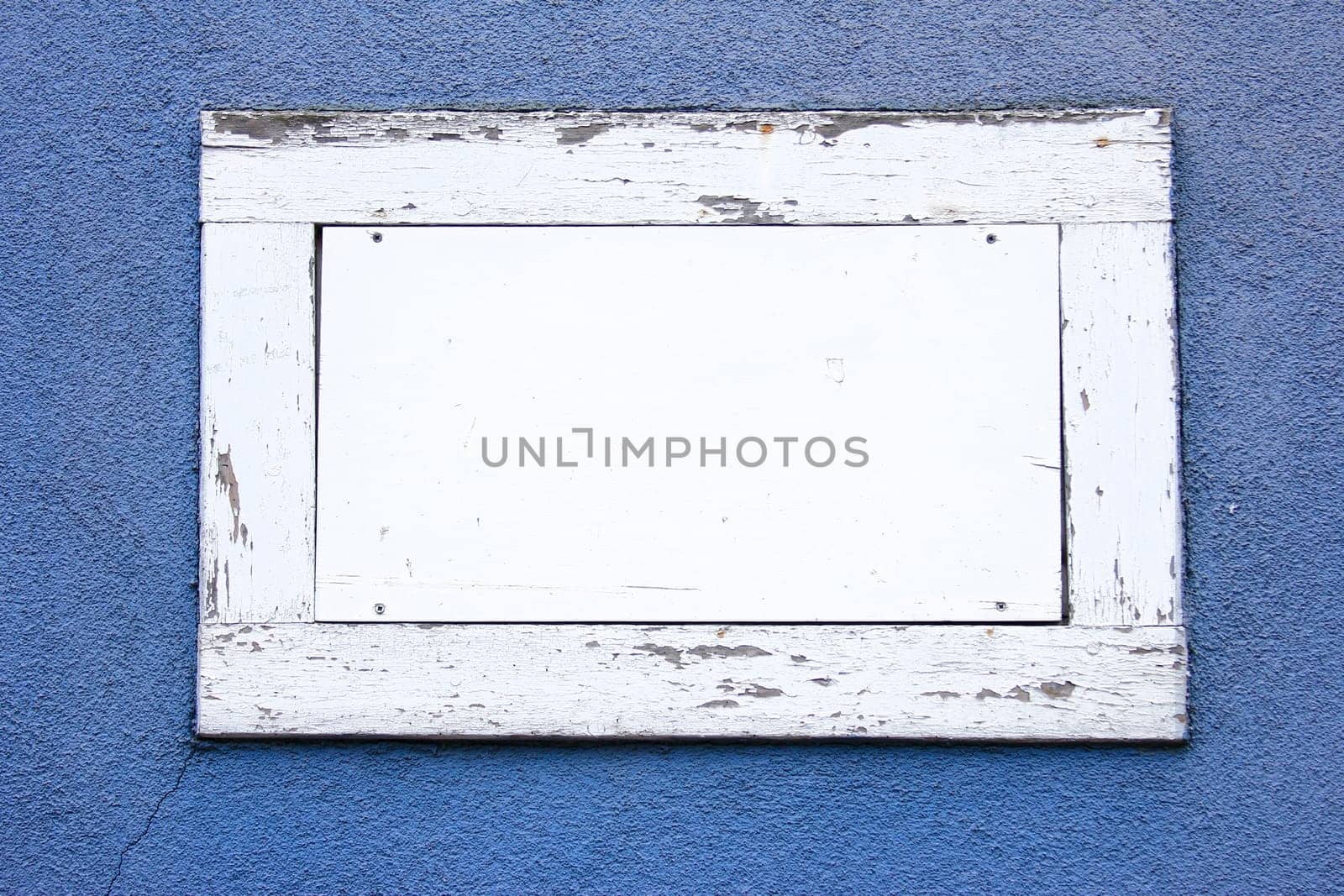 White wooden frame with white area as text box in a blue wall