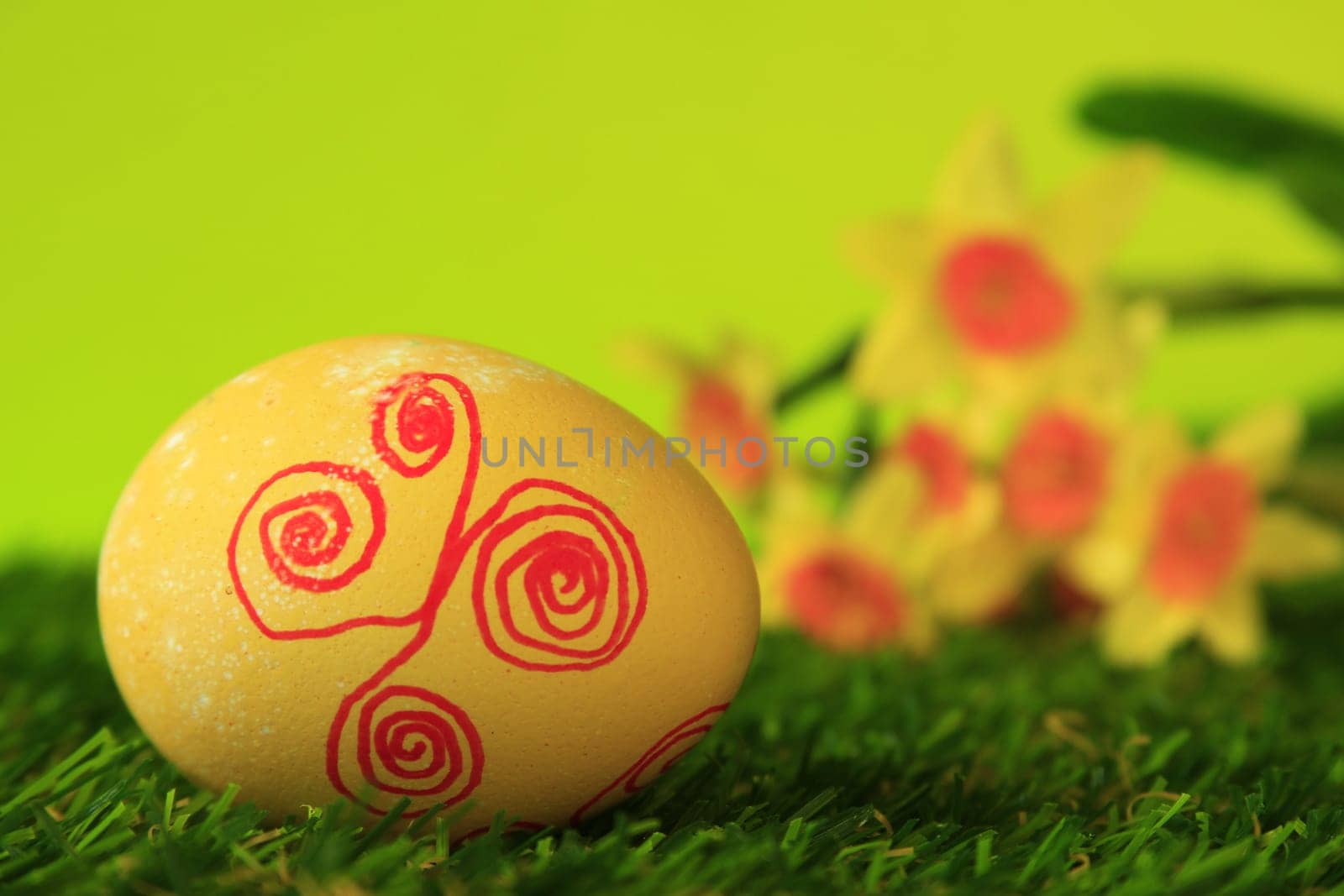 Easter decoration made of single,colorfully painted,Easter egg in green artificial grass