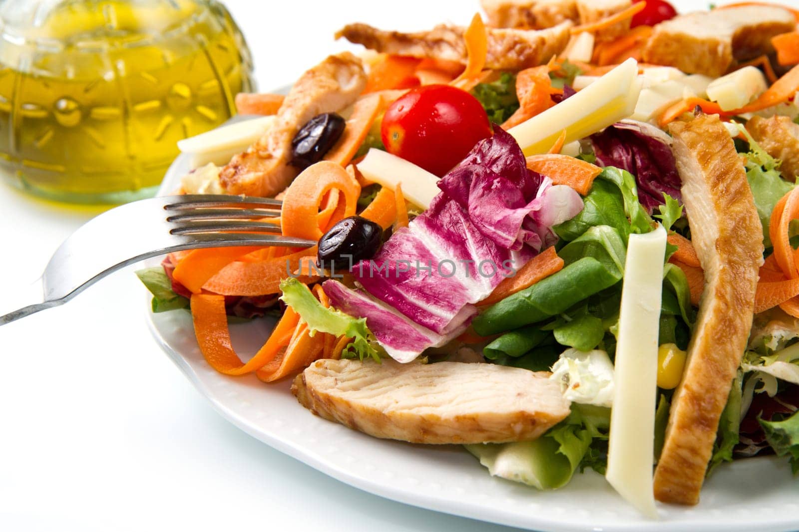 Chicken salad with fresh ingredients in the white bowl