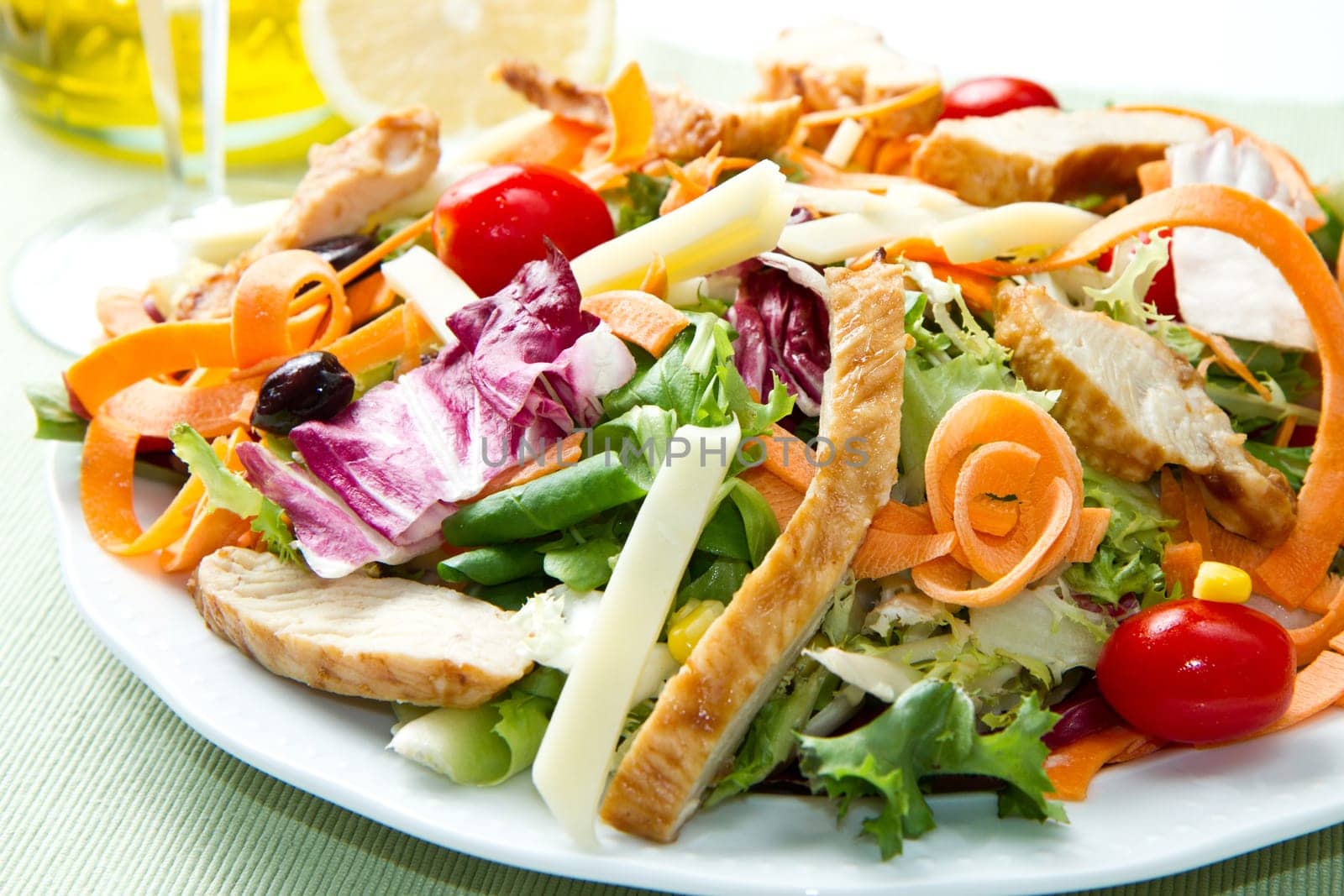 Chicken salad with fresh ingredients in the white bowl
