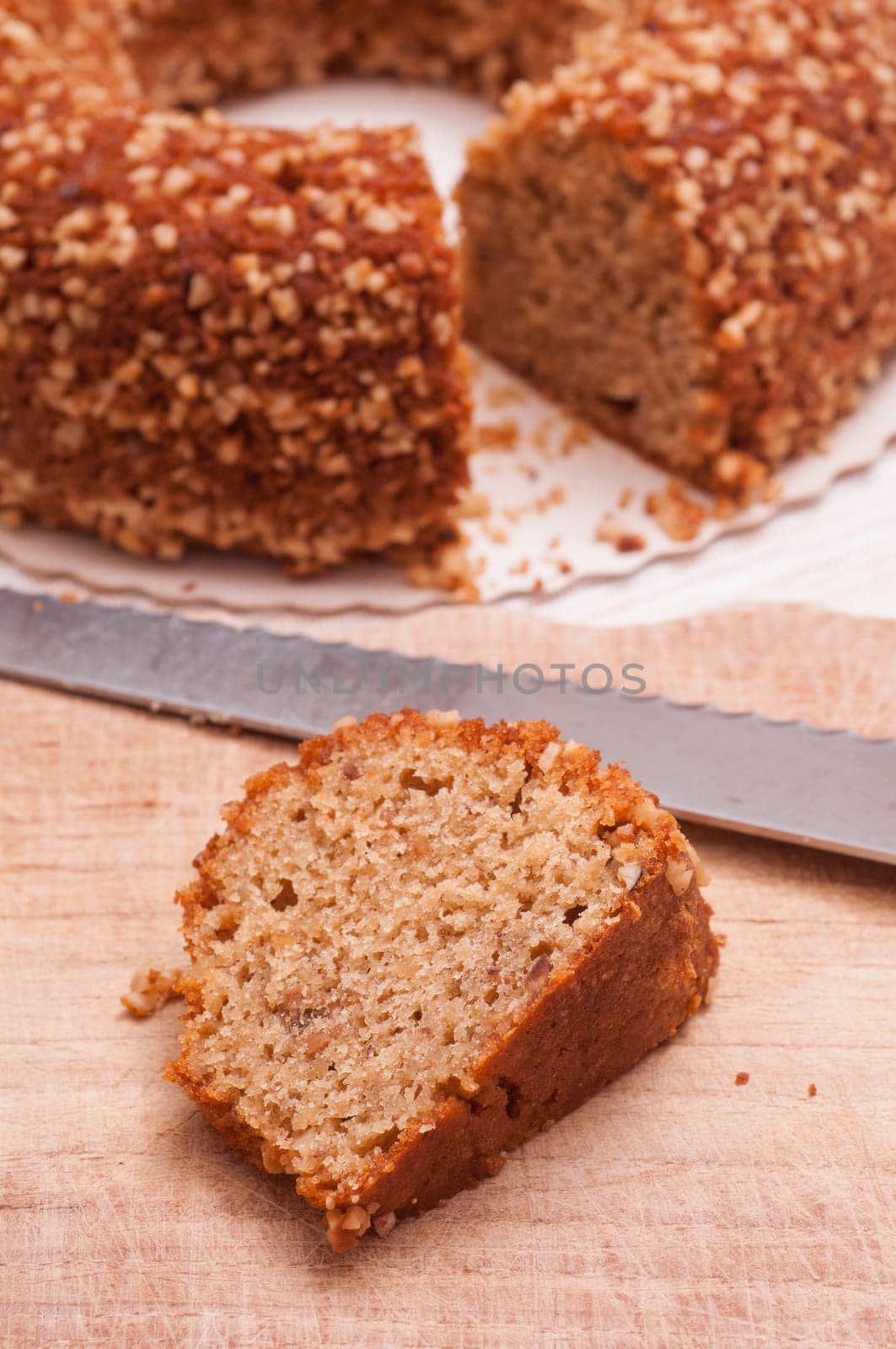 Piece of nut cake and cake knife in the background