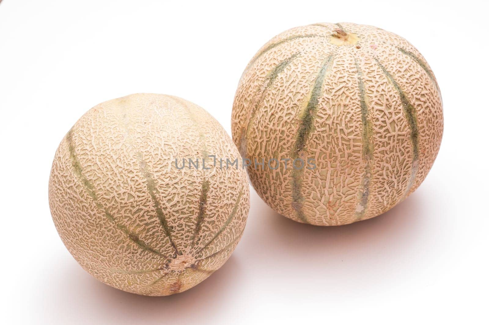 Two Charentais melons on white background