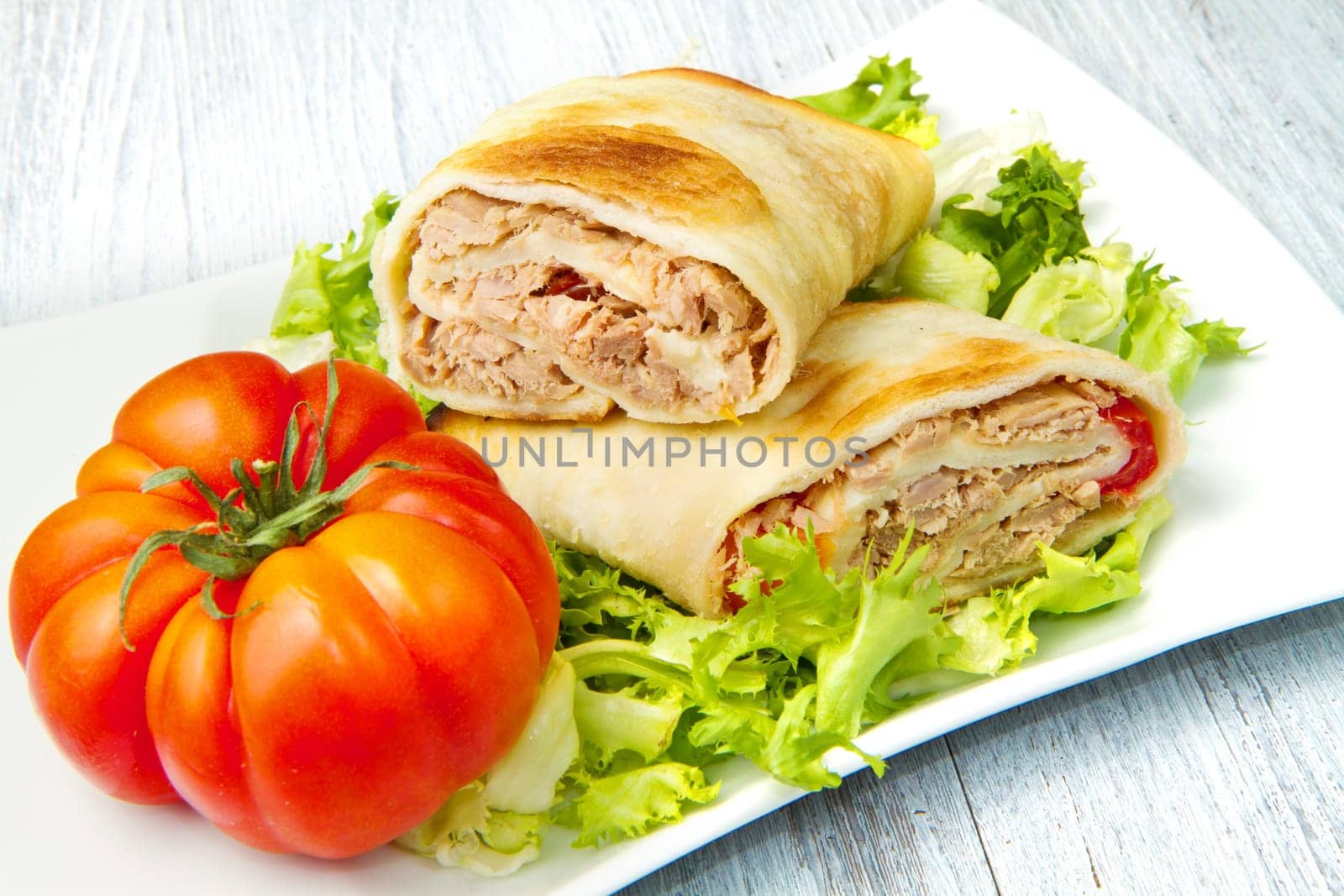 tuna sandwich on fresh salad and tomato
