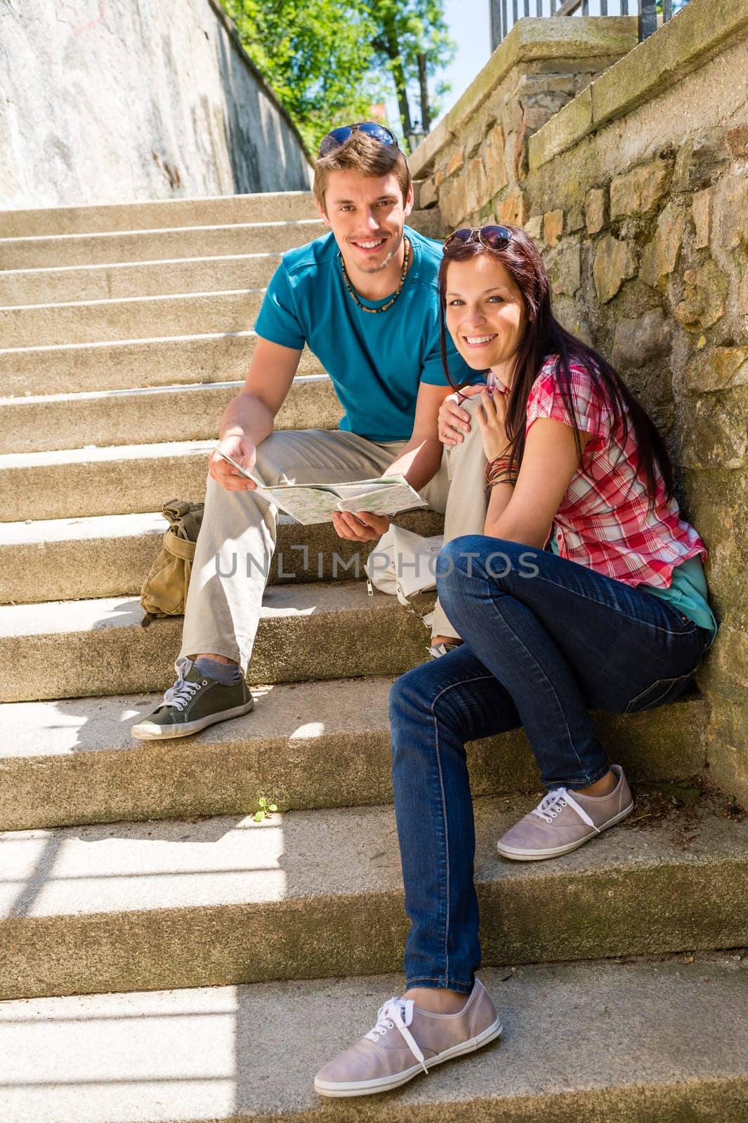 Young couple holding city map sunny day sightseeing together
