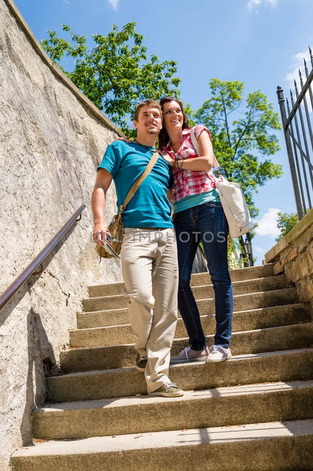 Young happy couple walking down stairs smiling in love
