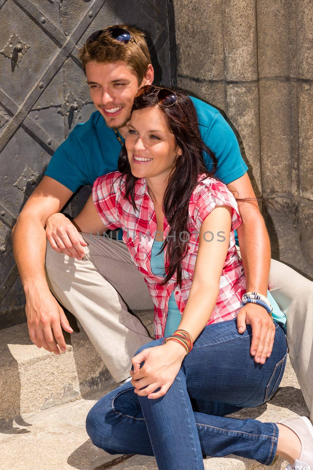 Young couple tourist sitting on doorstep smiling sunny day
