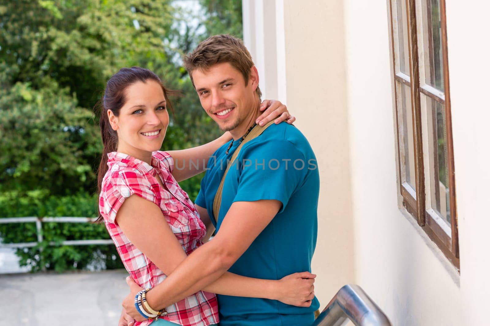 Happy young couple hugging in love smiling outdoors together