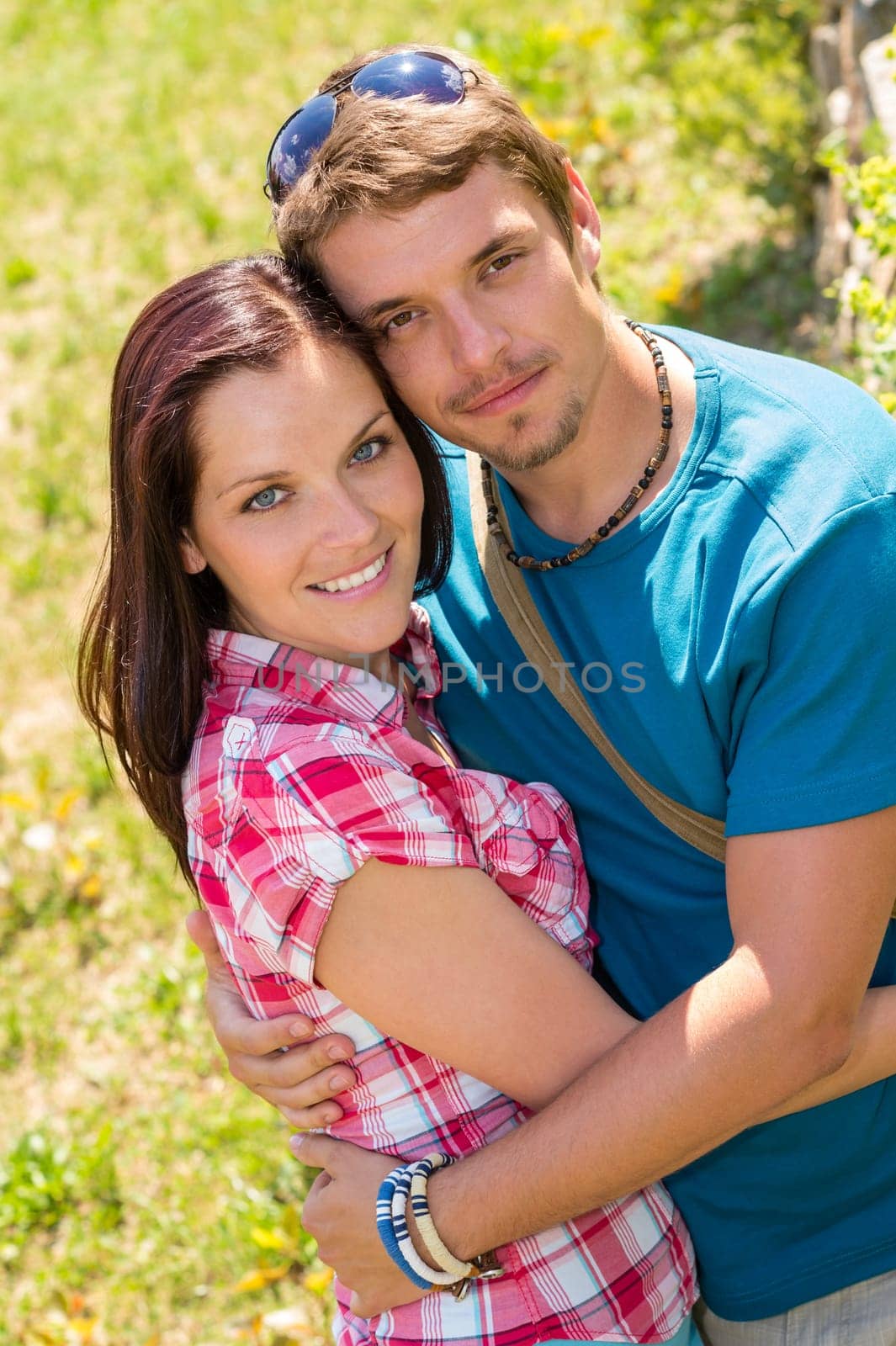 Happy affectionate young couple hugging in park smiling love romance
