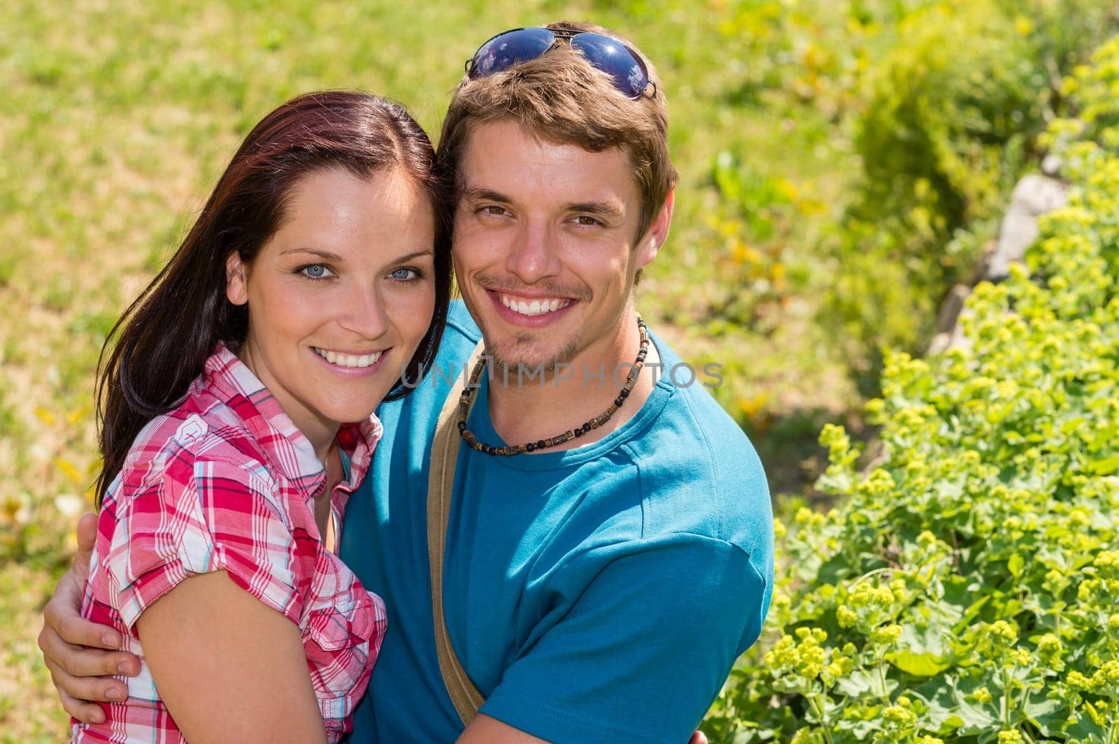 Young happy couple embracing in sunny park smiling pure romance