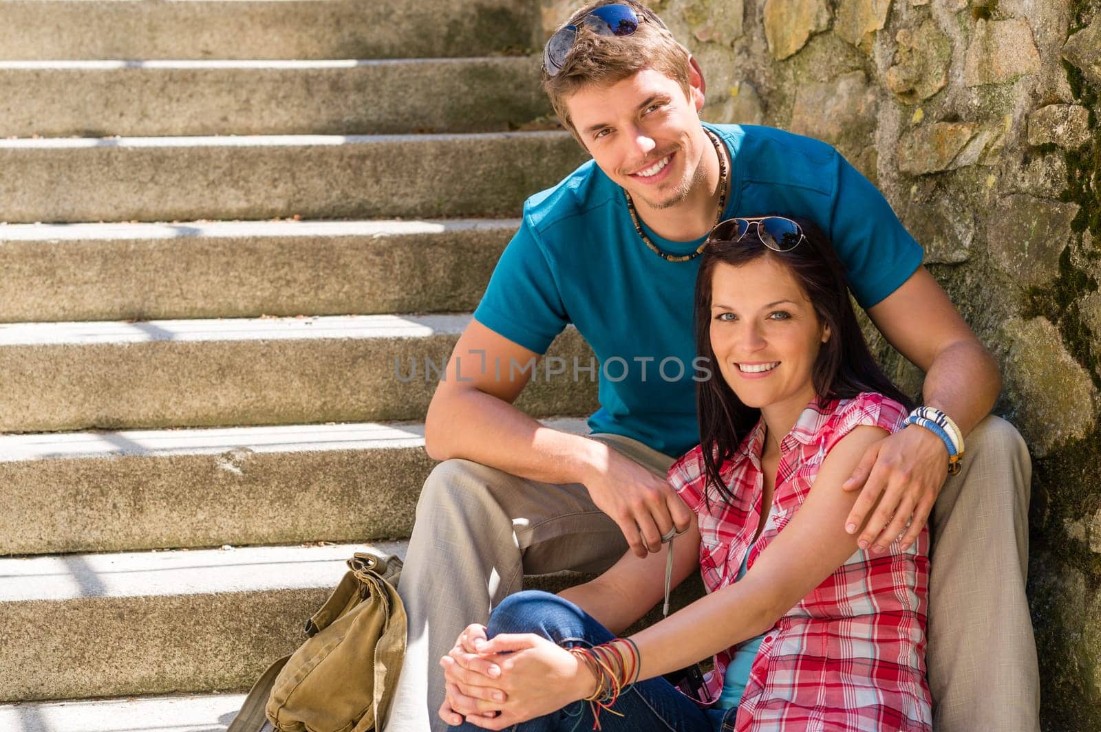Happy young couple sitting on stairs smiling love resting