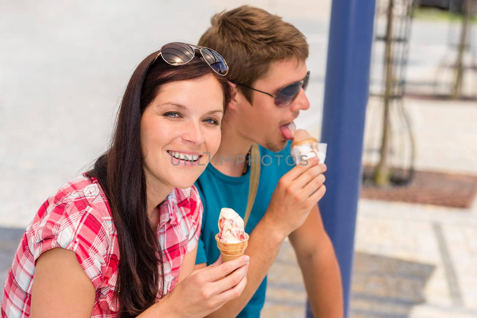 Young couple licking sweet ice cream on summer day