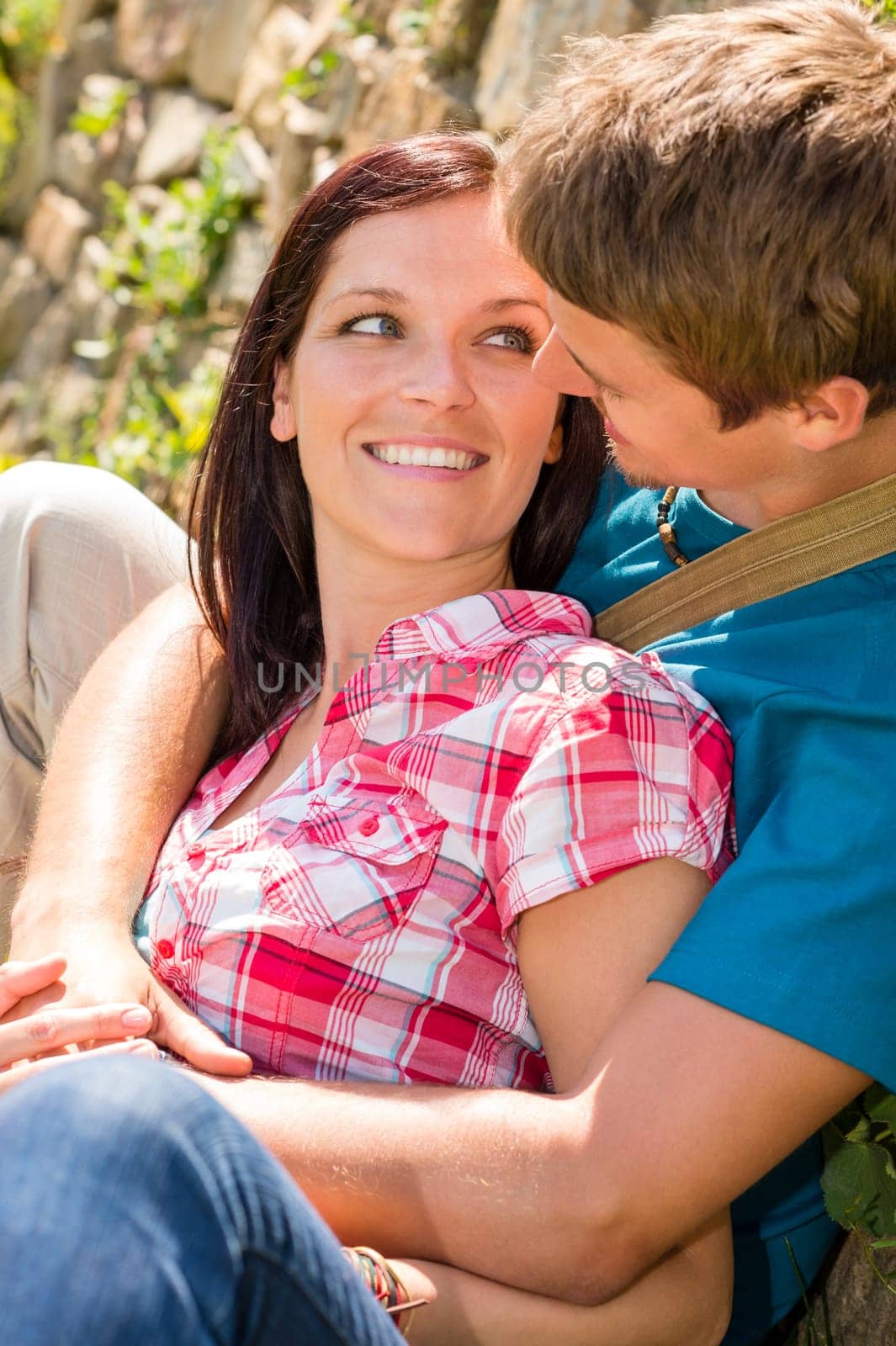 Young couple in love sitting outdoors looking at each other