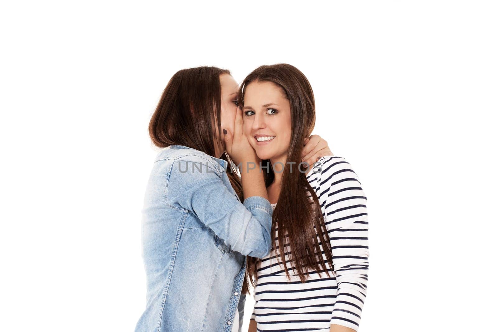 Girlfriends whispering on white background