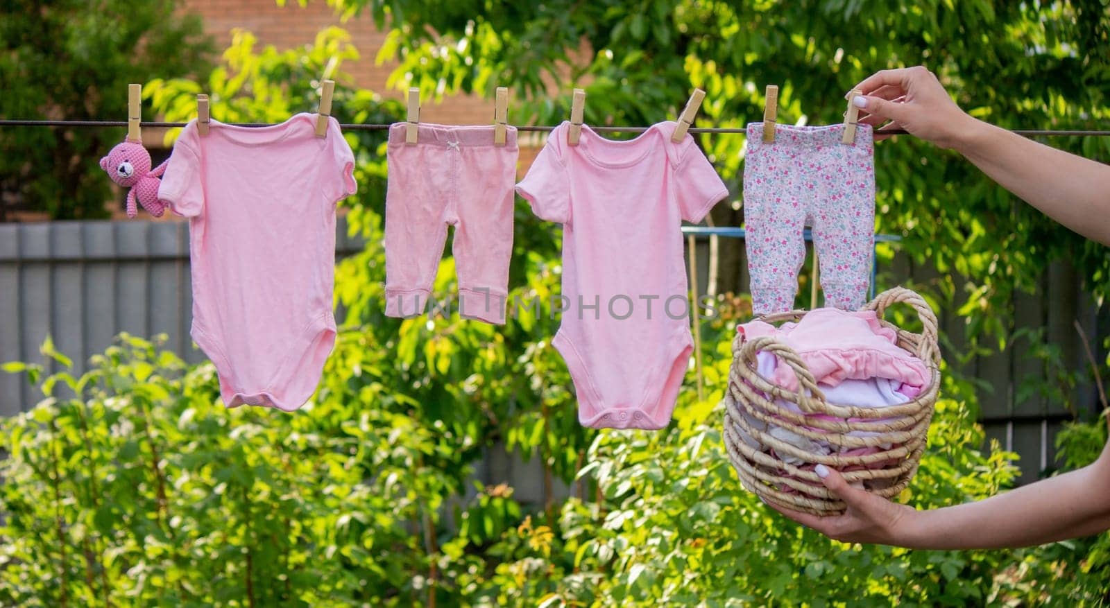 a woman hangs washed children's things in the fresh air. Selective focus. nature