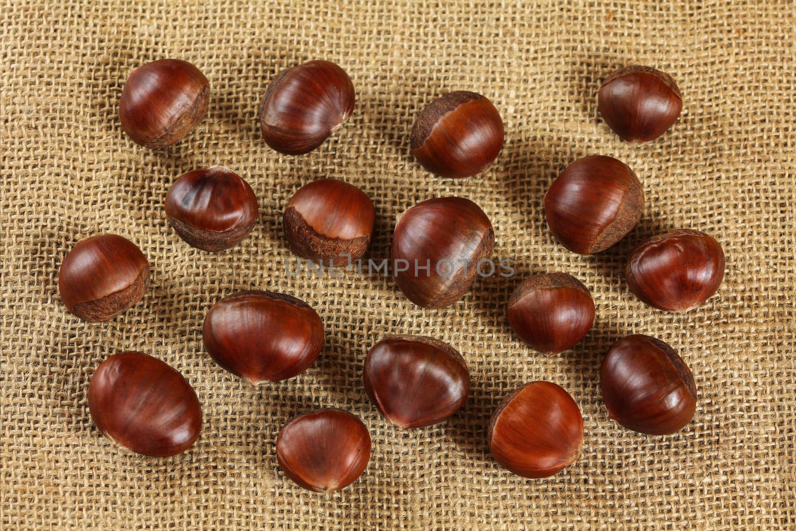 Shiny chestnuts on jute textile, photo from above by Ivanko