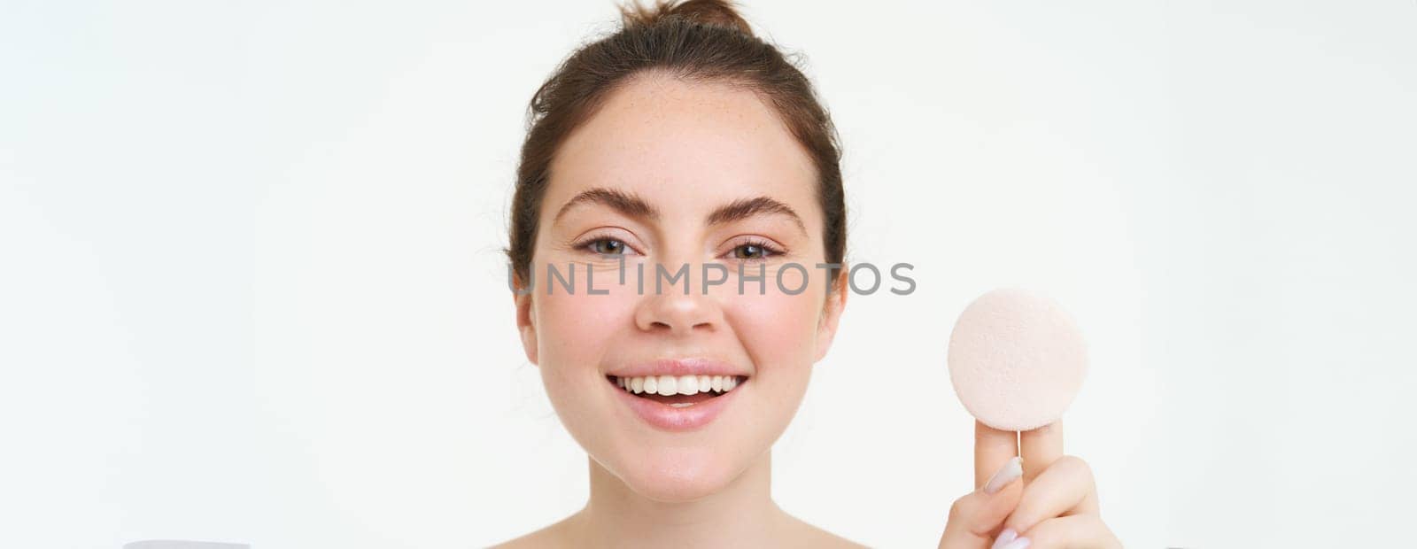 Wellbeing and skin care concept. Beauty woman shows cotton pad after washing her face with cleanser, using toner to take off makeup, standing over white background.