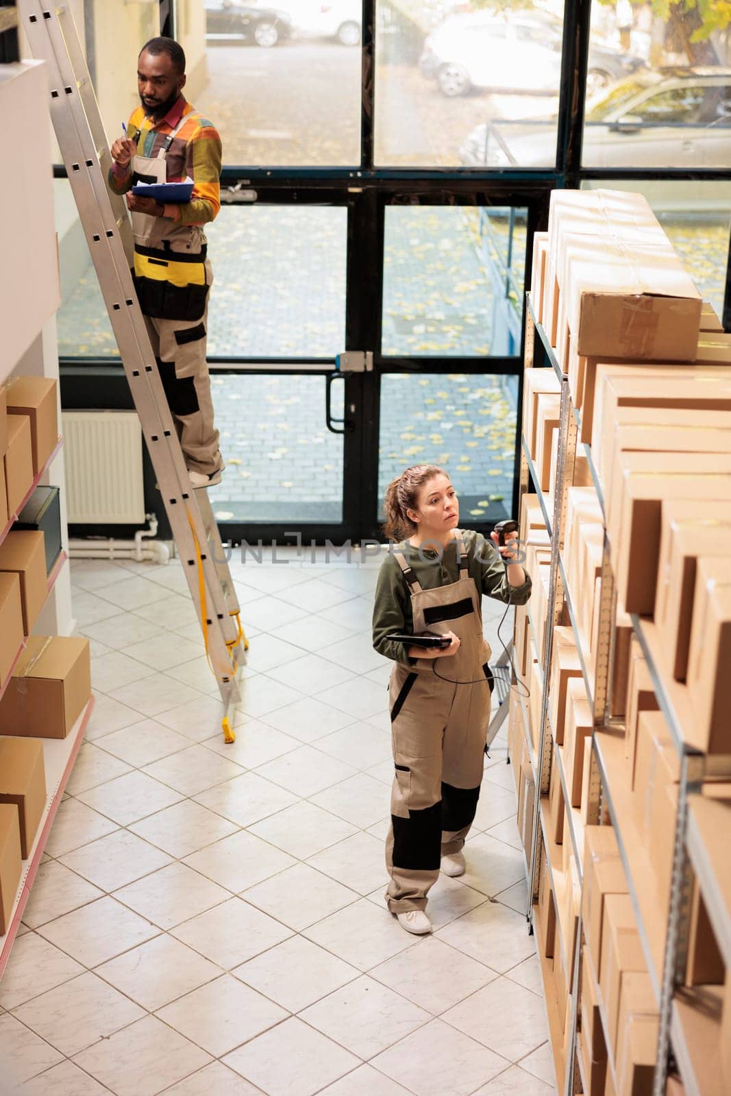 Stockroom employee scanning boxes using store scanner by DCStudio