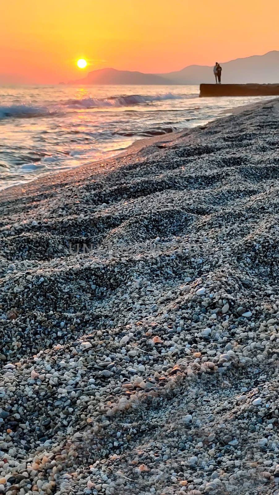 Landscape of beautiful seashore with sunset on background of sea, vertical frame