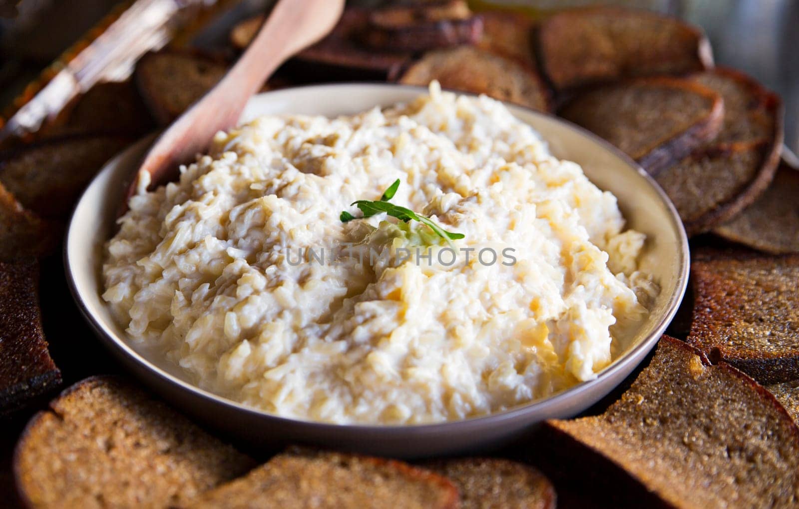 Bred and porridge in dish lay on table