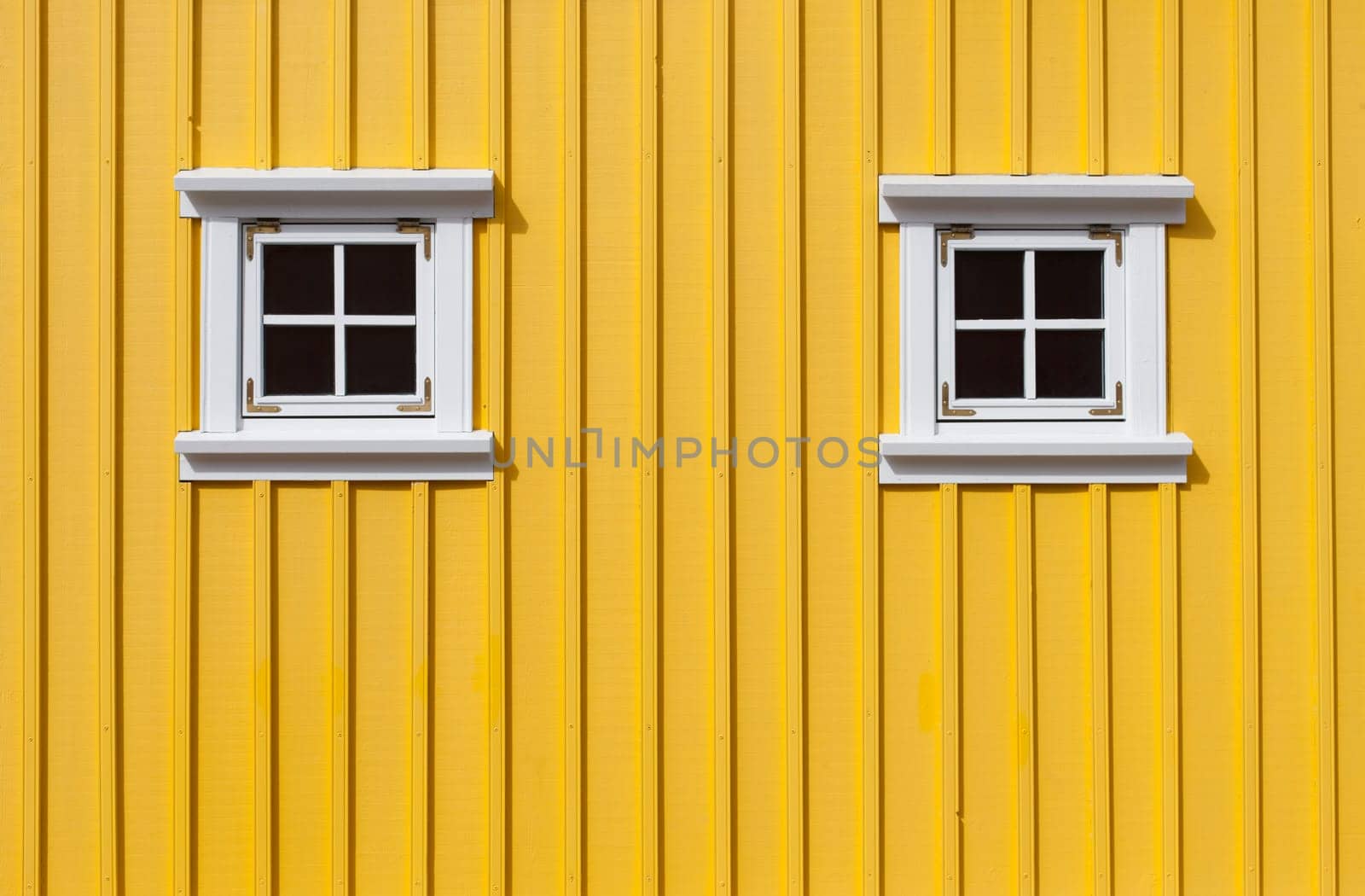 Bright yellow timber wall with two small windows