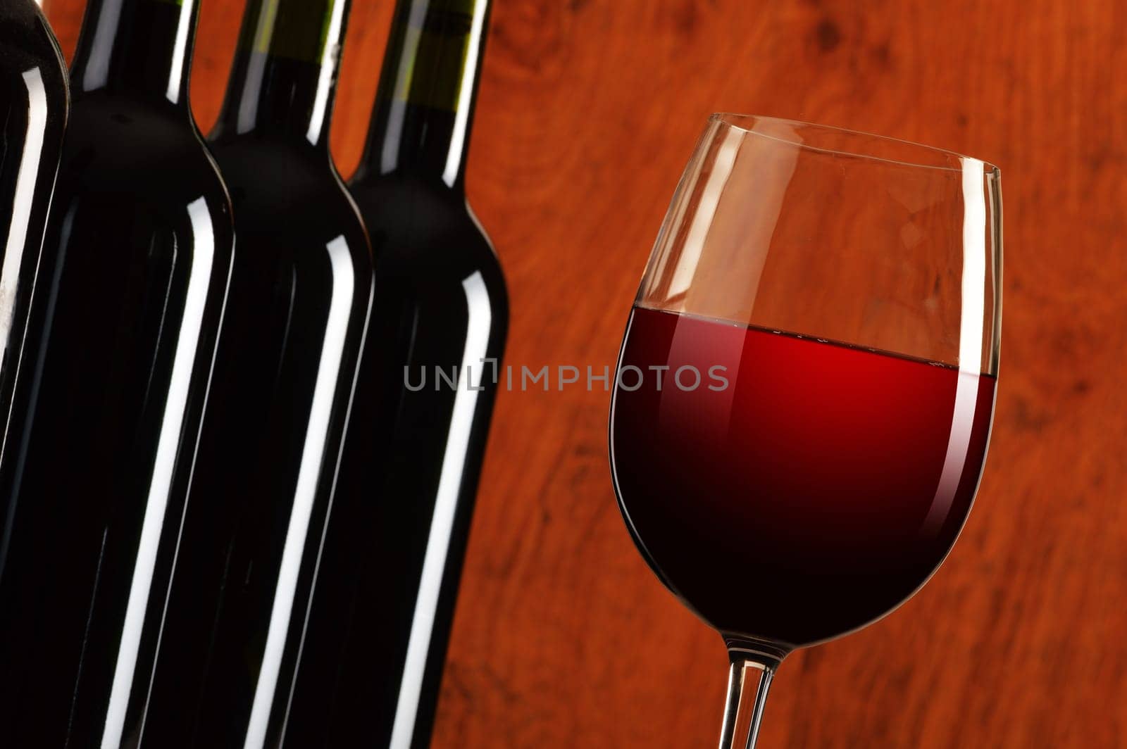Composition with wineglass and bottles of red wine