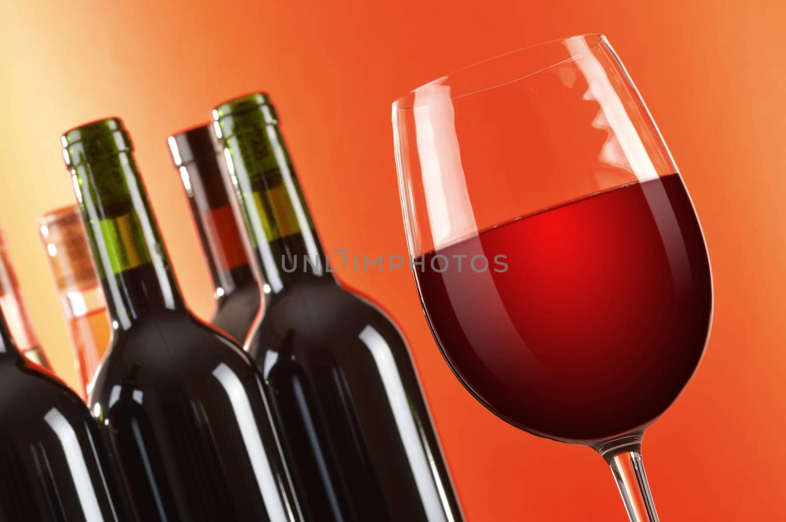 Composition with wineglass and bottles of red wine