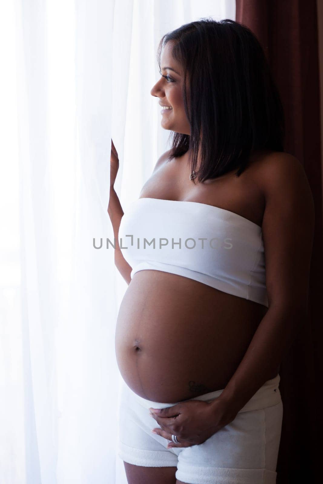 Young beautiful pregnant indian touching her tummy