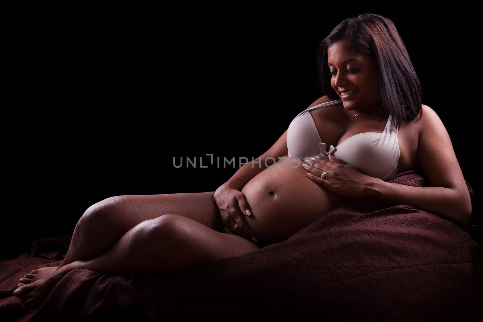 Young beautiful pregnant indian woman touching her belly