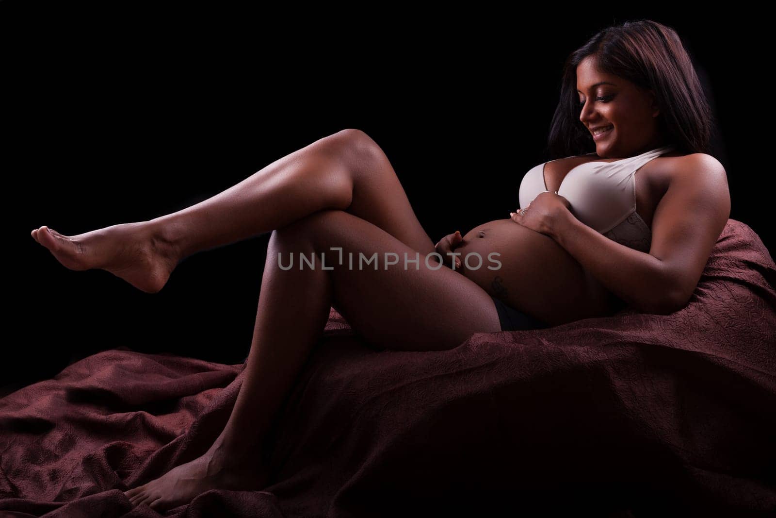 Young beautiful pregnant indian woman touching her belly