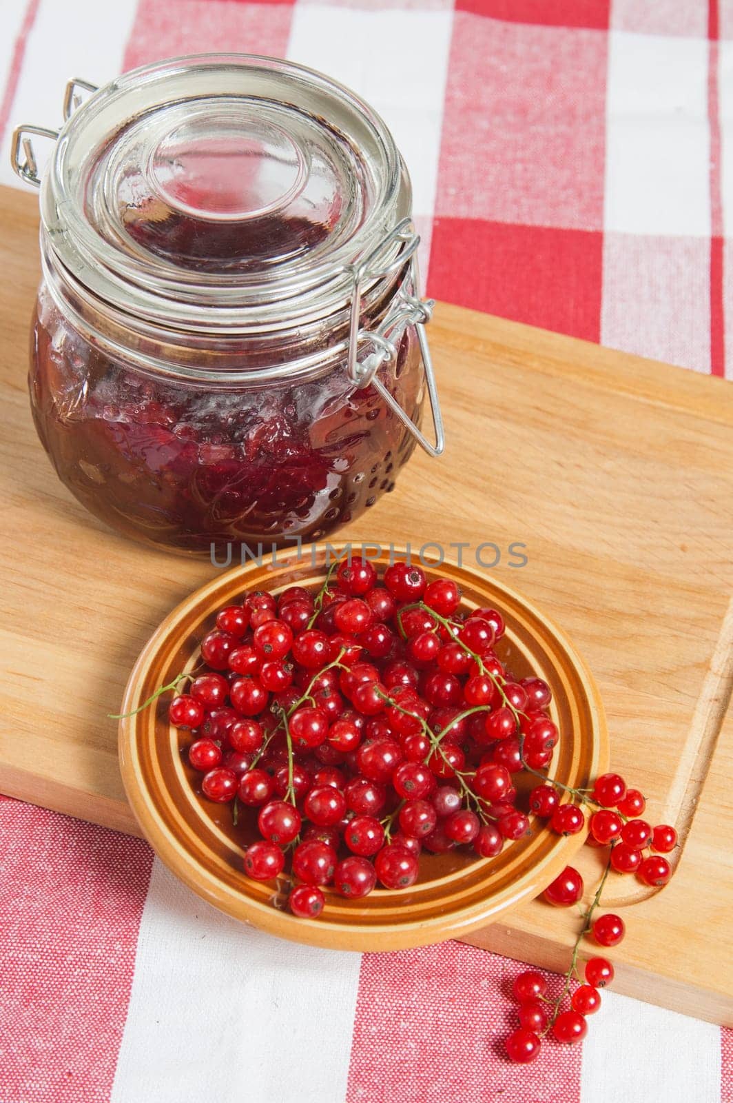 Jam with berries of a red currant on a table.