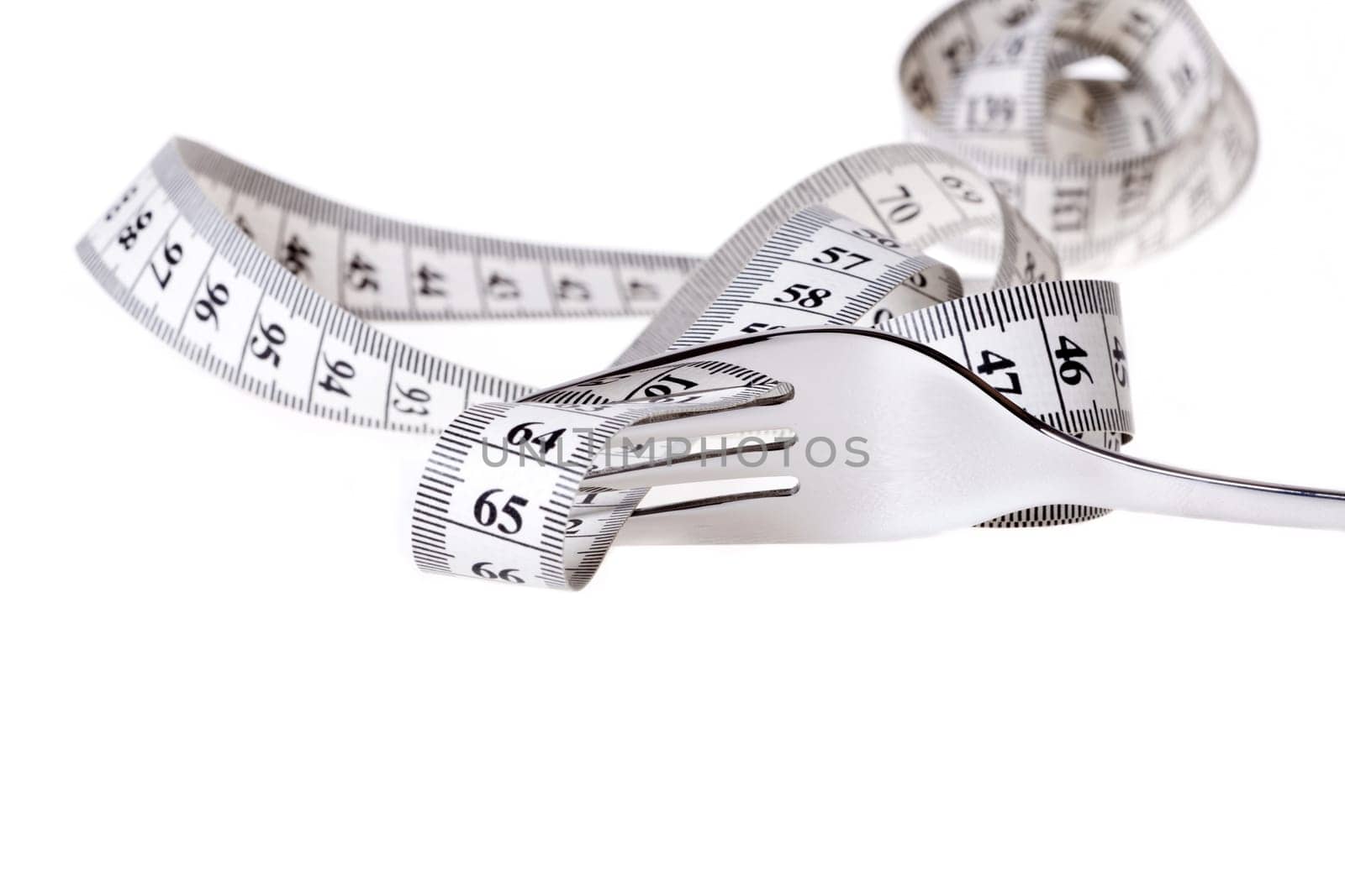 Measuring tape is guided by a fork against a white background