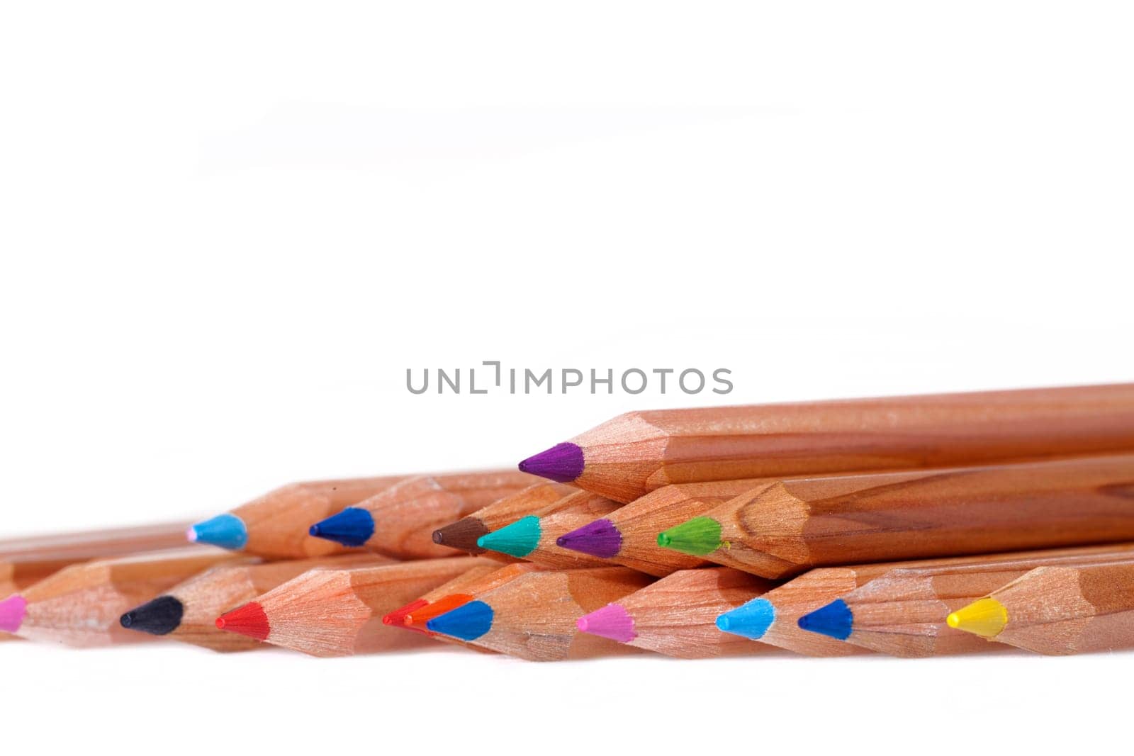 Colored crayons in a row as a close-up shot against white background