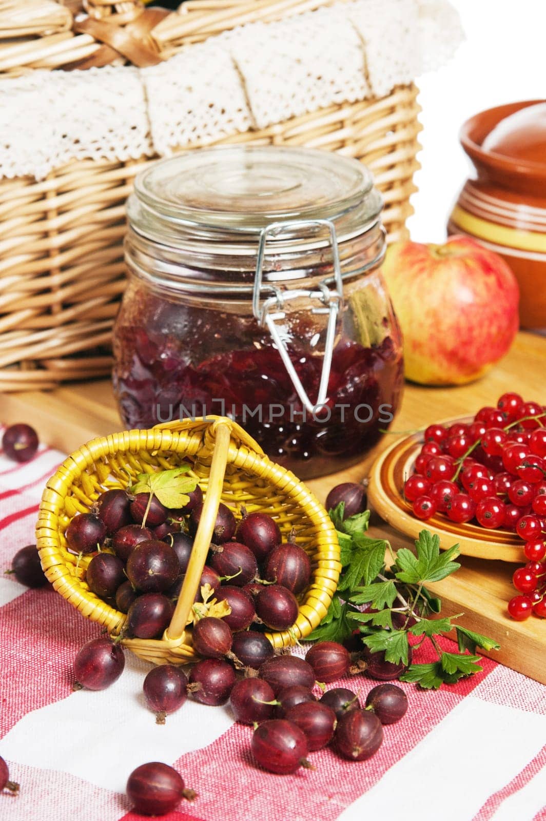Jam with berries of red currant and gooseberry on the table