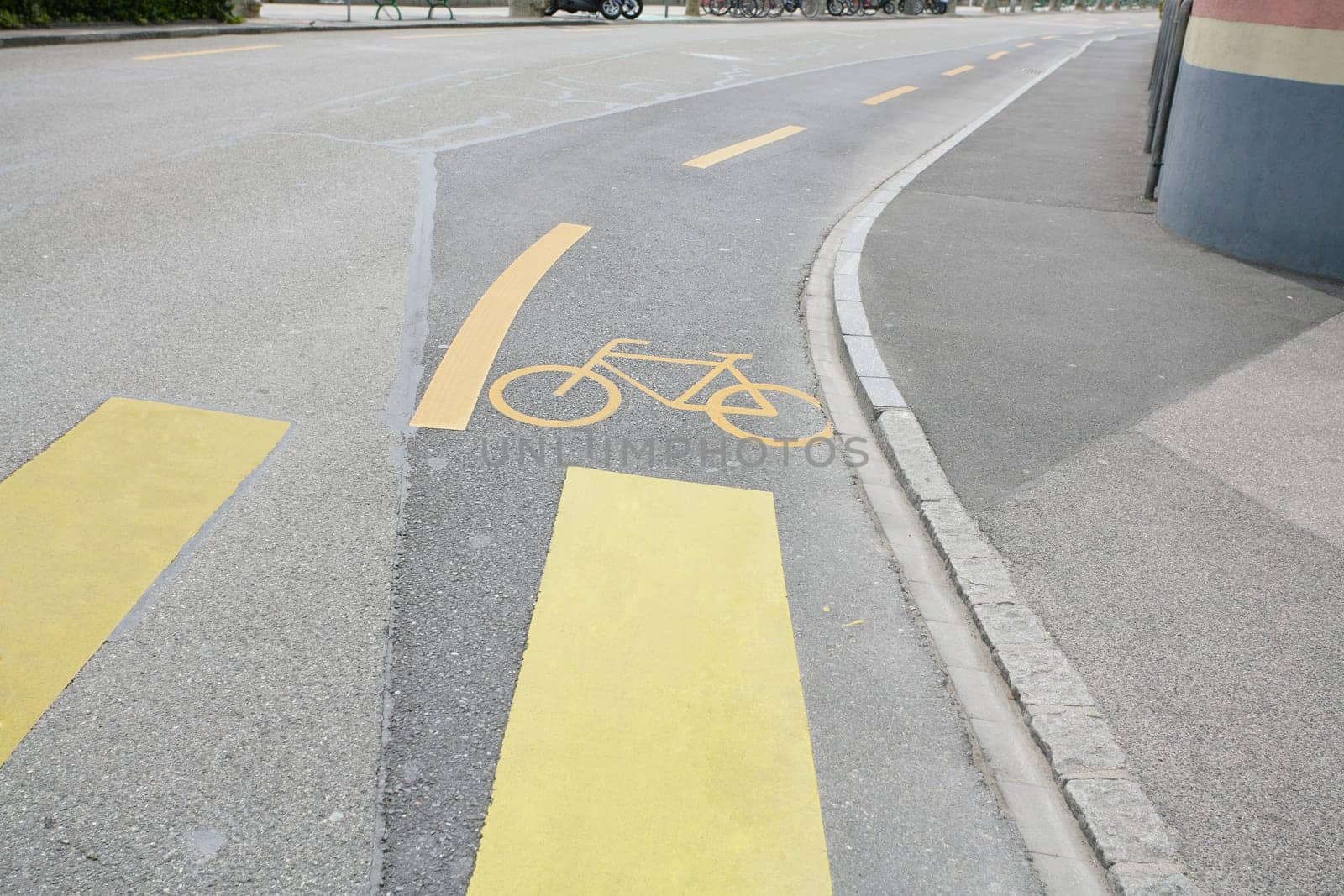 Yellow painted sign for bikes on asphalt