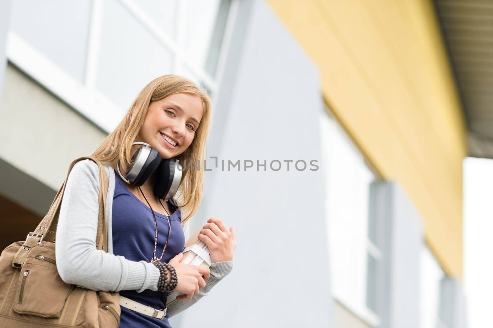 Student carrying books to school headphones happy young teenage girl