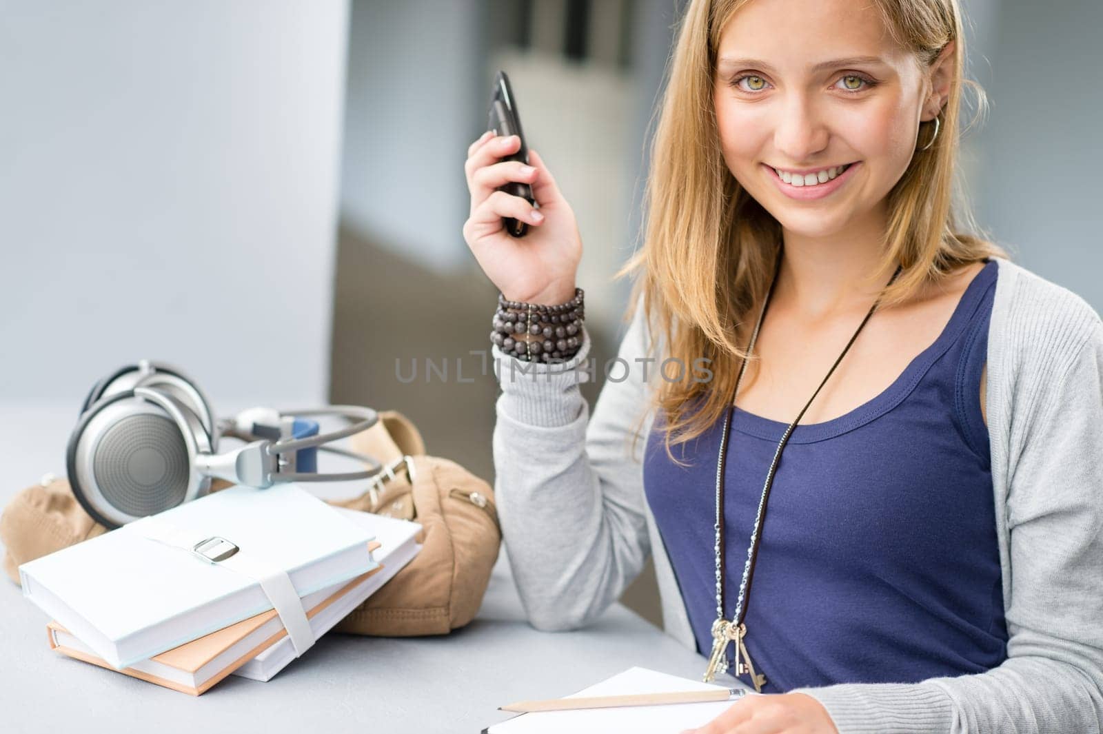 Student woman with notes and cellphone smiling teenage girl