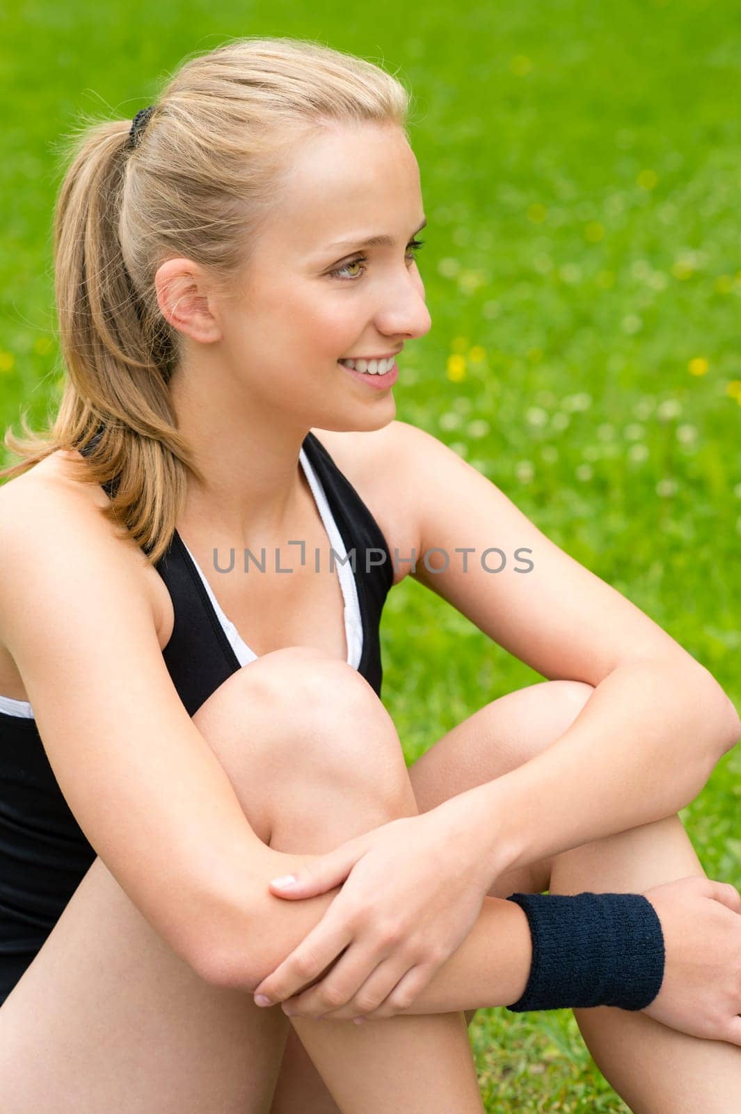 Young woman resting after workout on lawn happy smiling sport