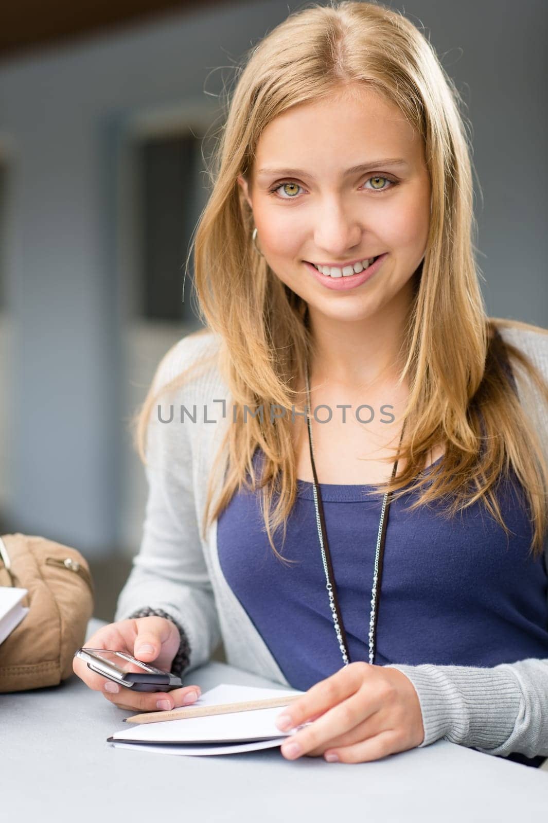 Teenage woman with notes and cellphone student young happy smiling