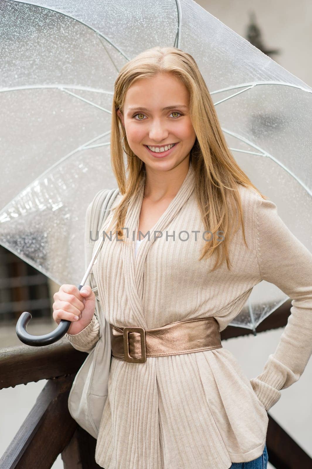 Young happy woman in rain with umbrella smiling city outfit