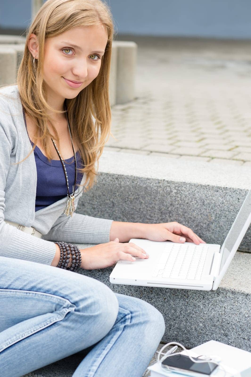 Teenage girl study with laptop computer sitting stairs outdoor