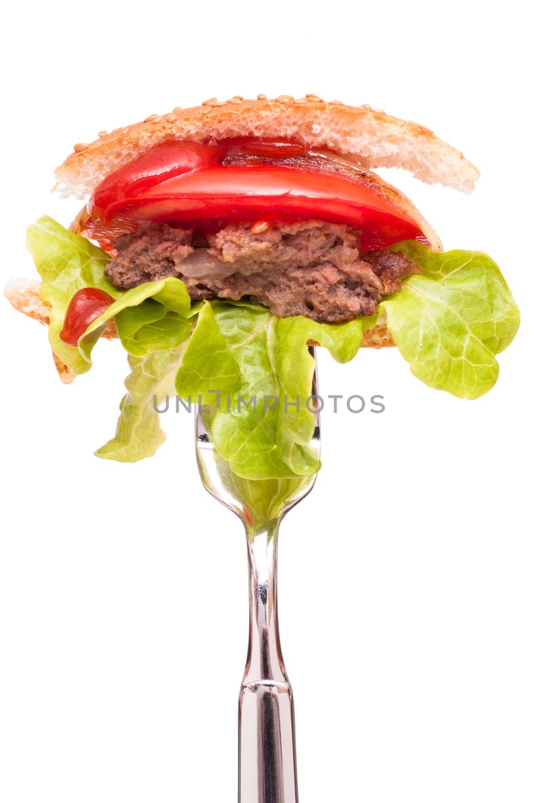 Hamburger with beef,lettuce leaf,tomato and ketchup on a fork