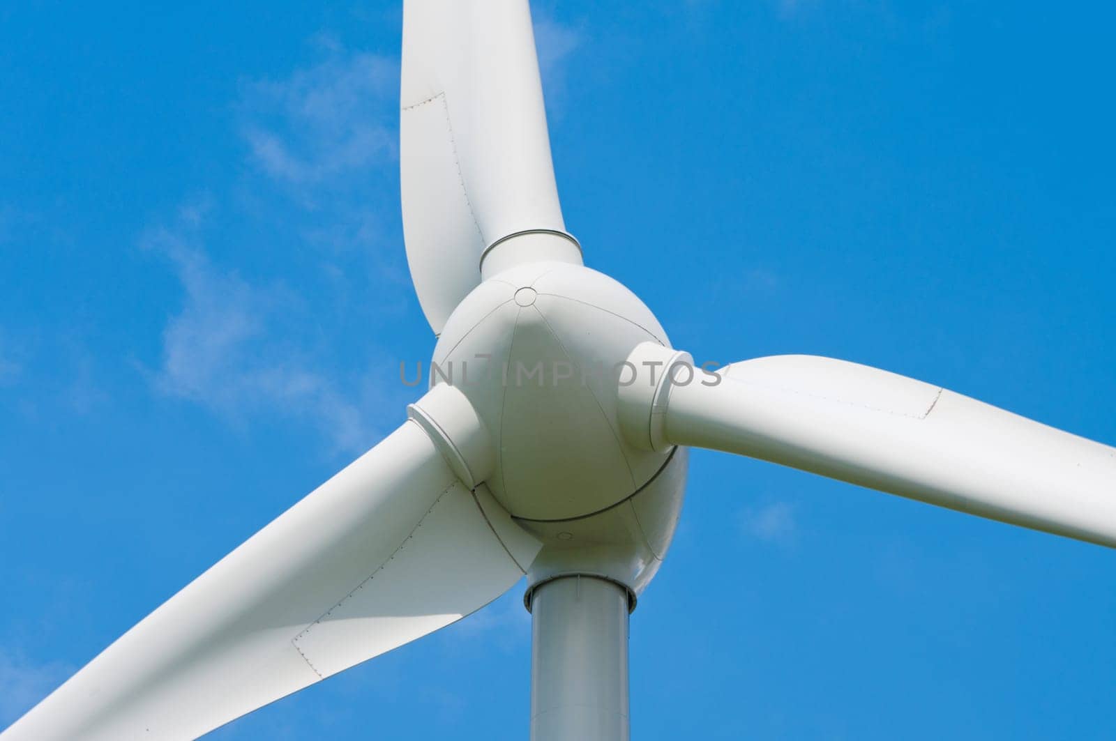 closeup of a windturbine against a blue sky