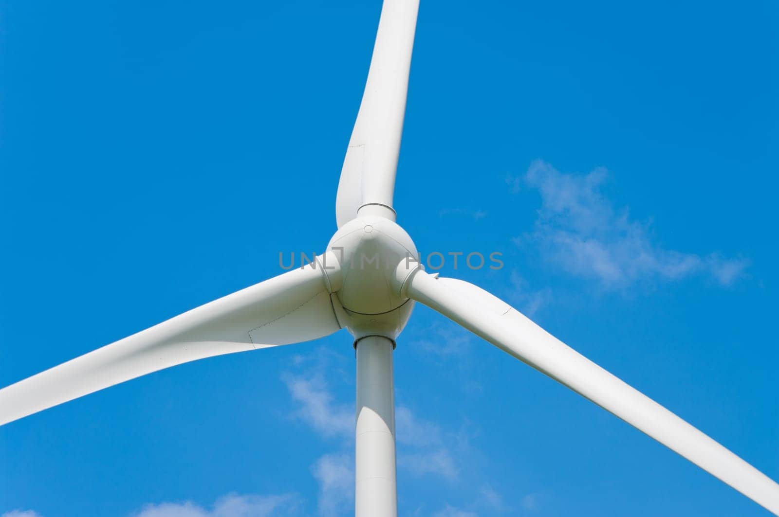 closeup of a windturbine against a blue sky