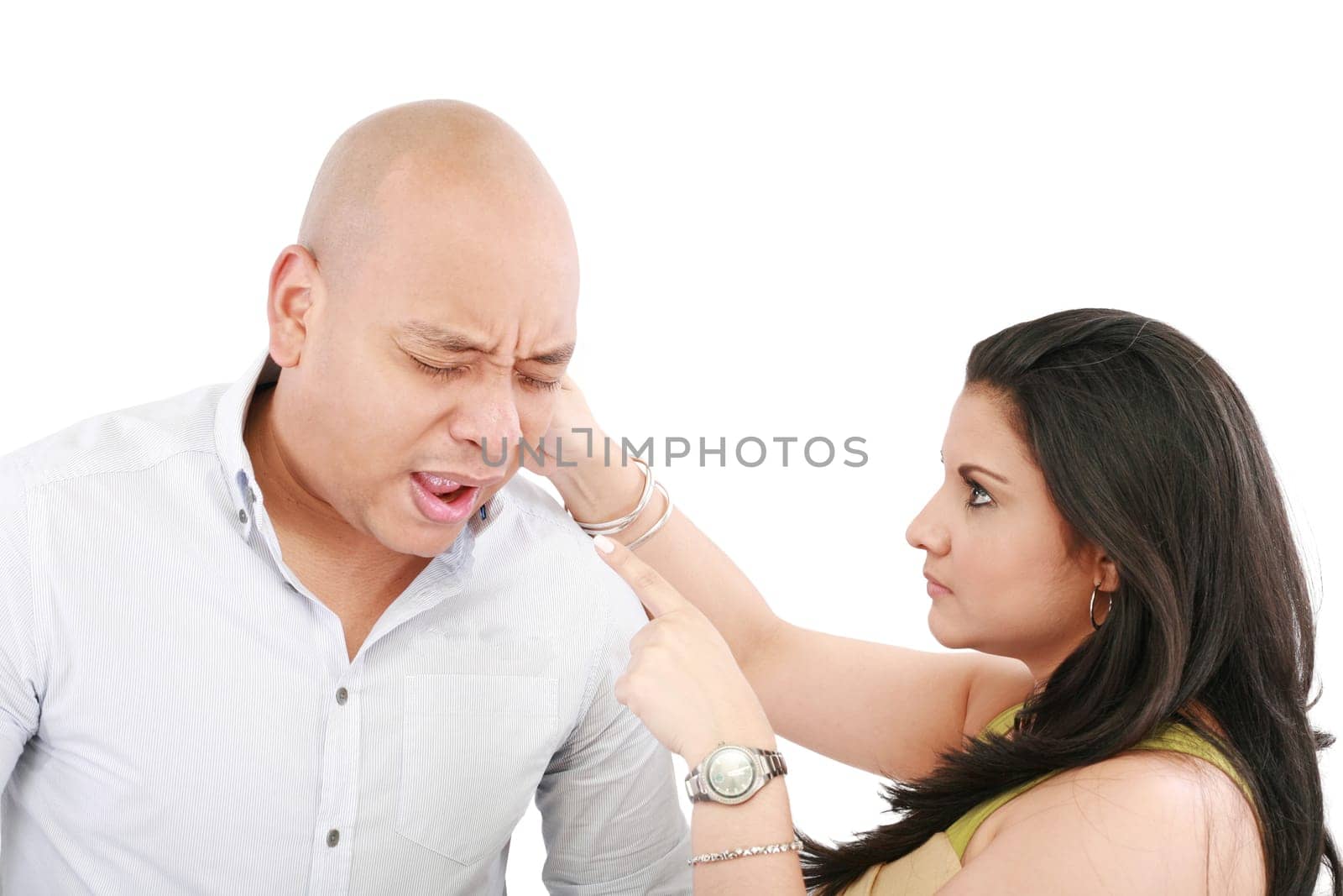 Beautiful Caucasian woman twisting boyfriend's ear while he screams