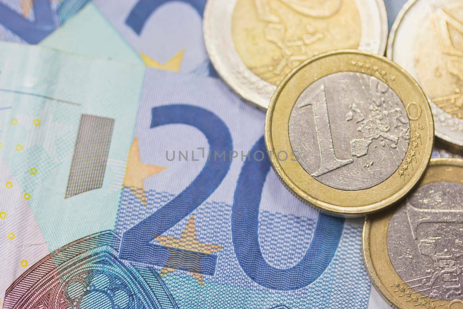 Detailed view of euro coins lying on paper money. Background.