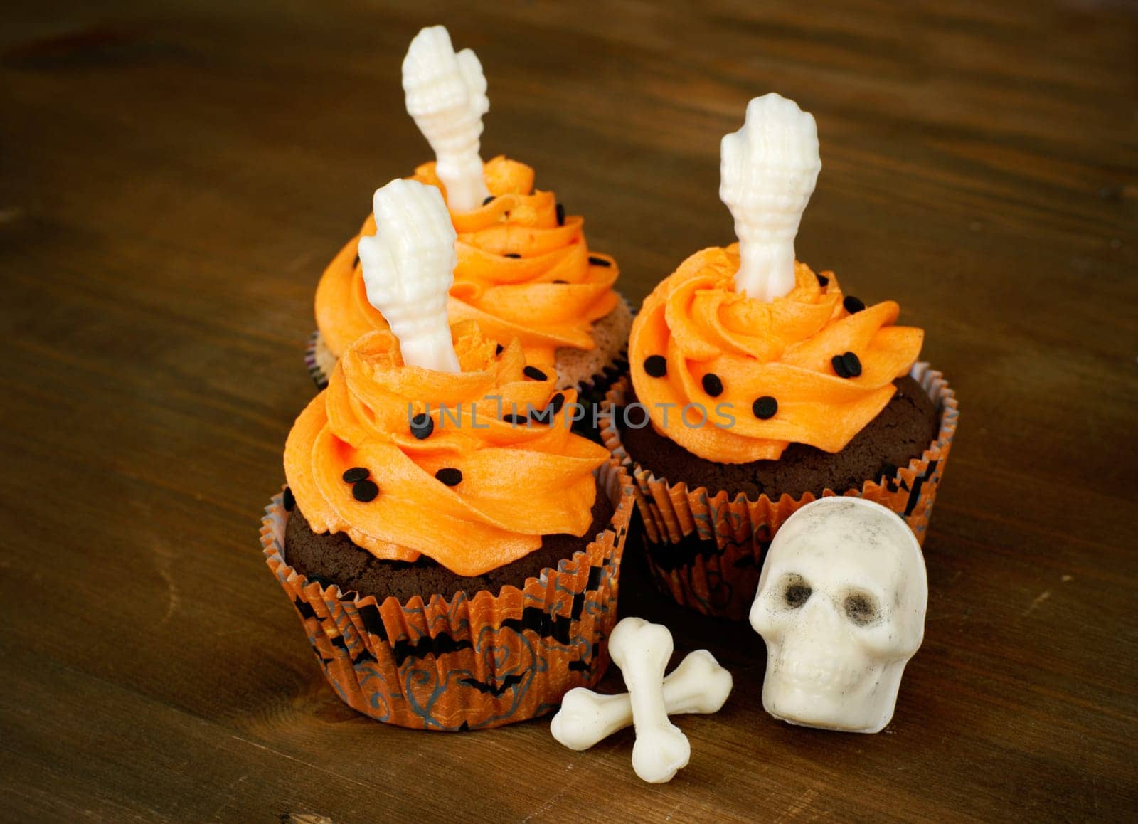 Chocolate cupcakes decorated with white chocolate skeleton parts.