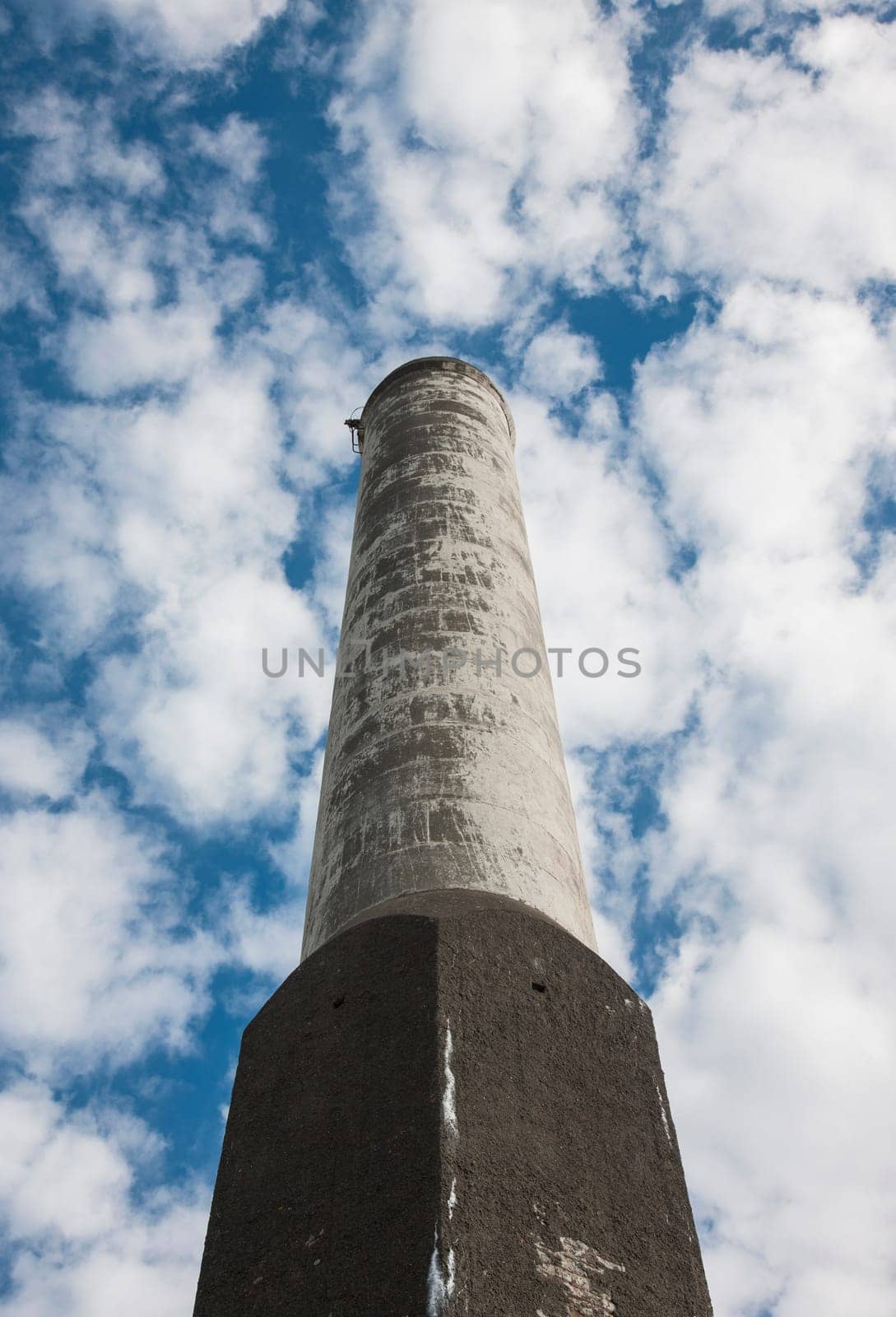 Old factory chimney no longer polluting the air against a blue summer sky
