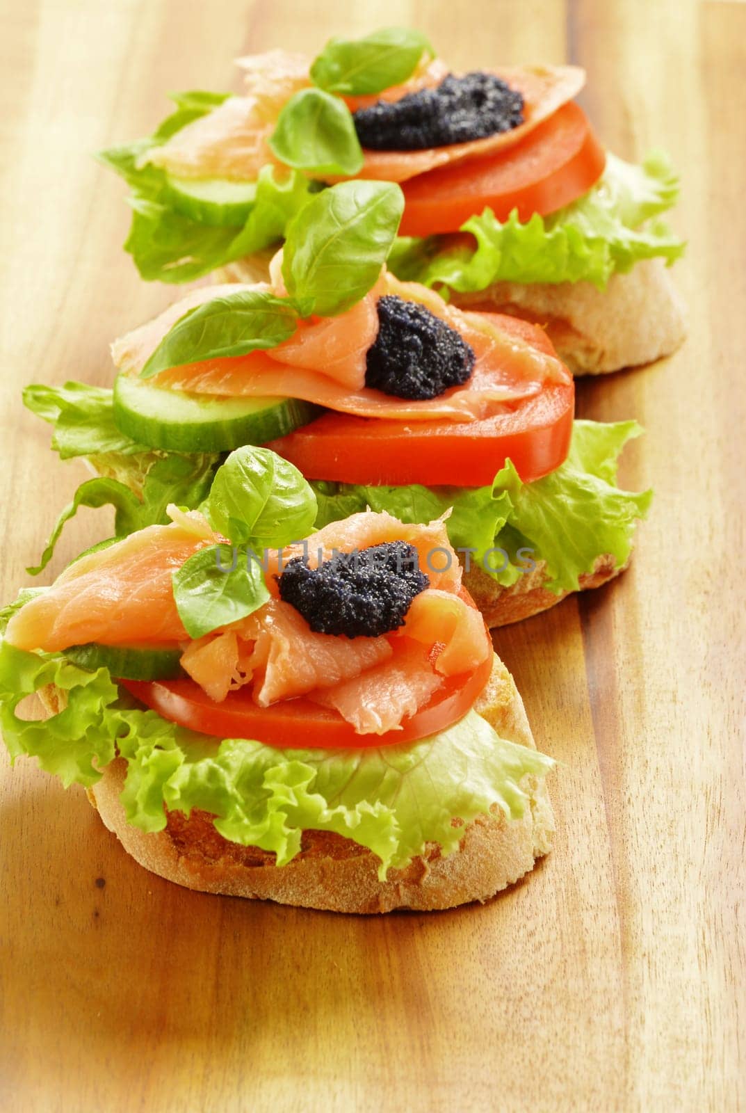 Three sandwiches with salmon and caviar. Fish snack