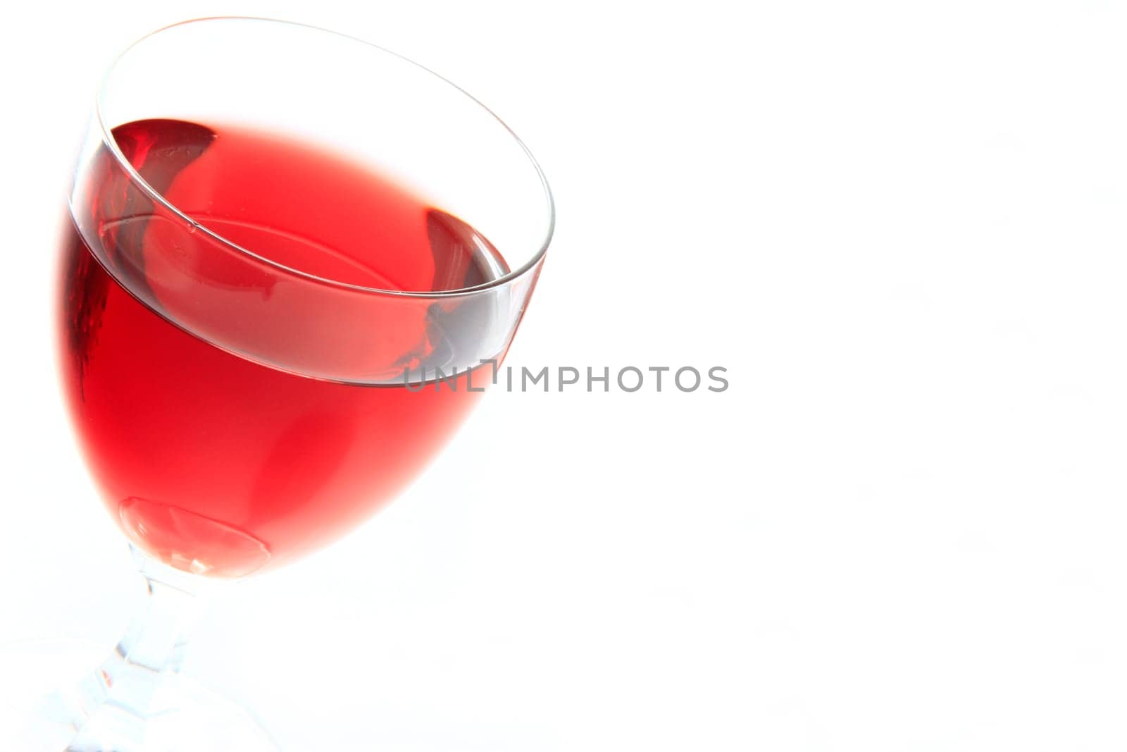 Glass with red wine against white background