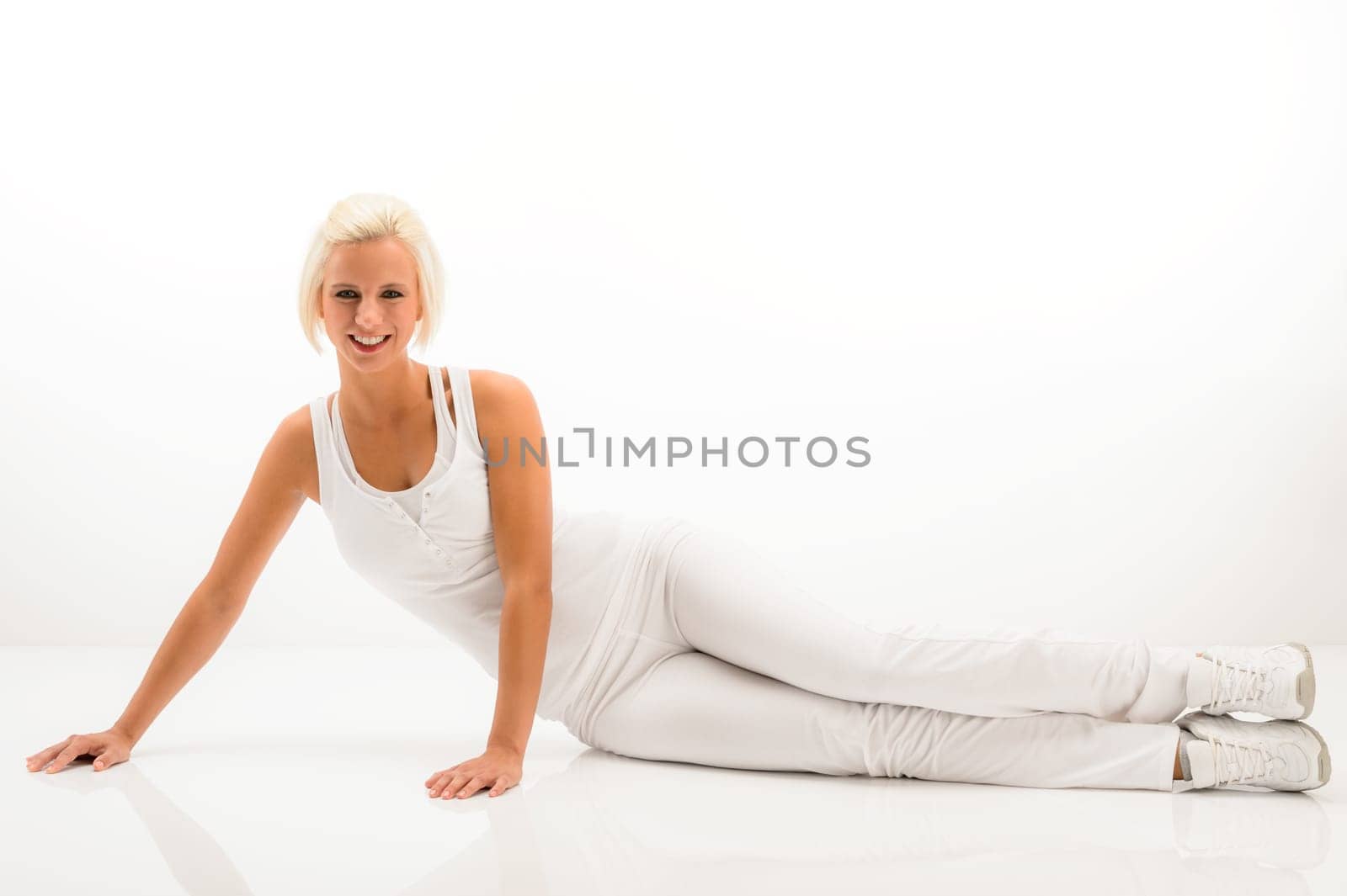 Woman stretching her body fitness exercise sitting on white floor
